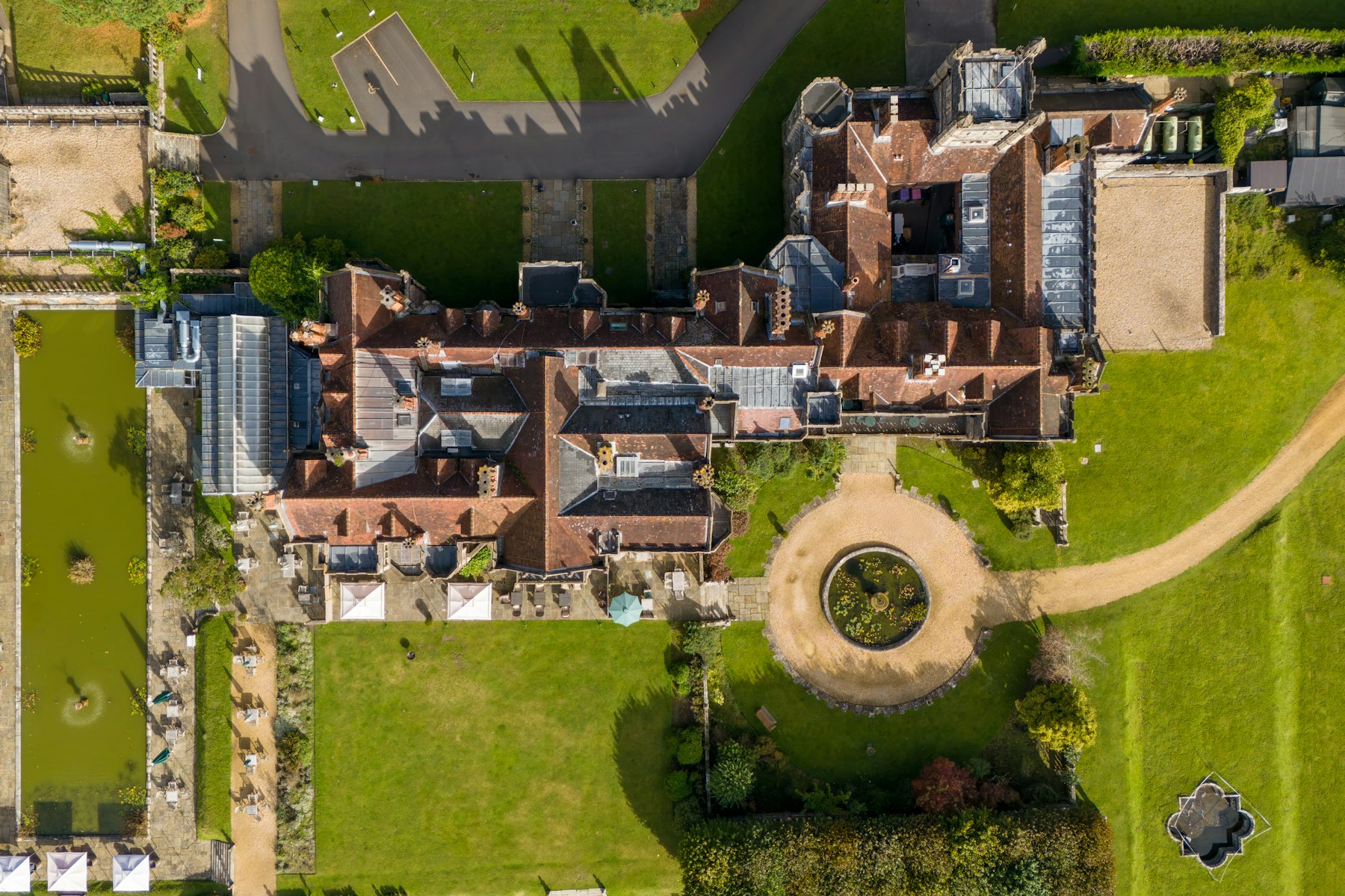 Aerial view of a large historic manor house with formal gardens