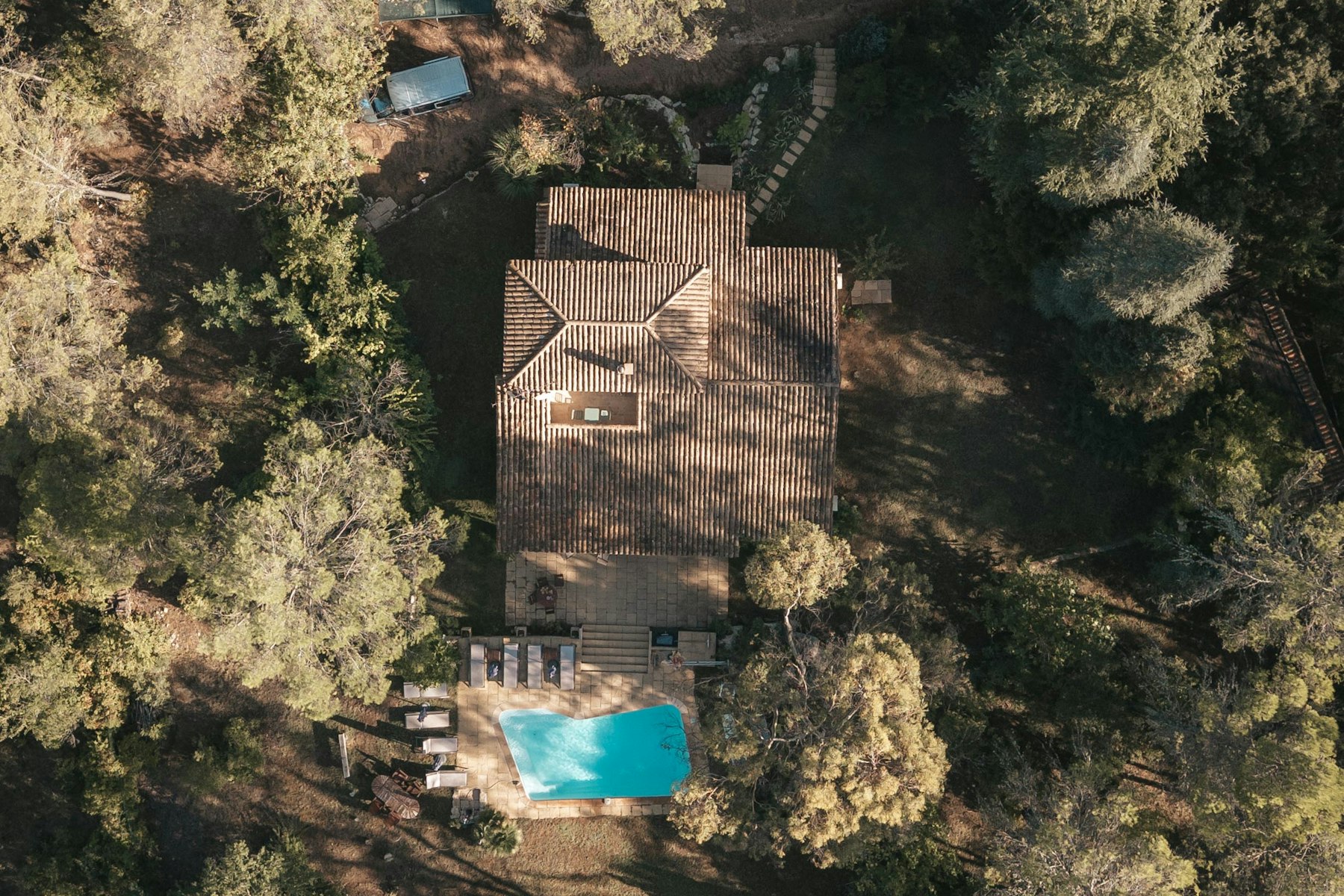 Aerial view of house with pool surrounded by trees